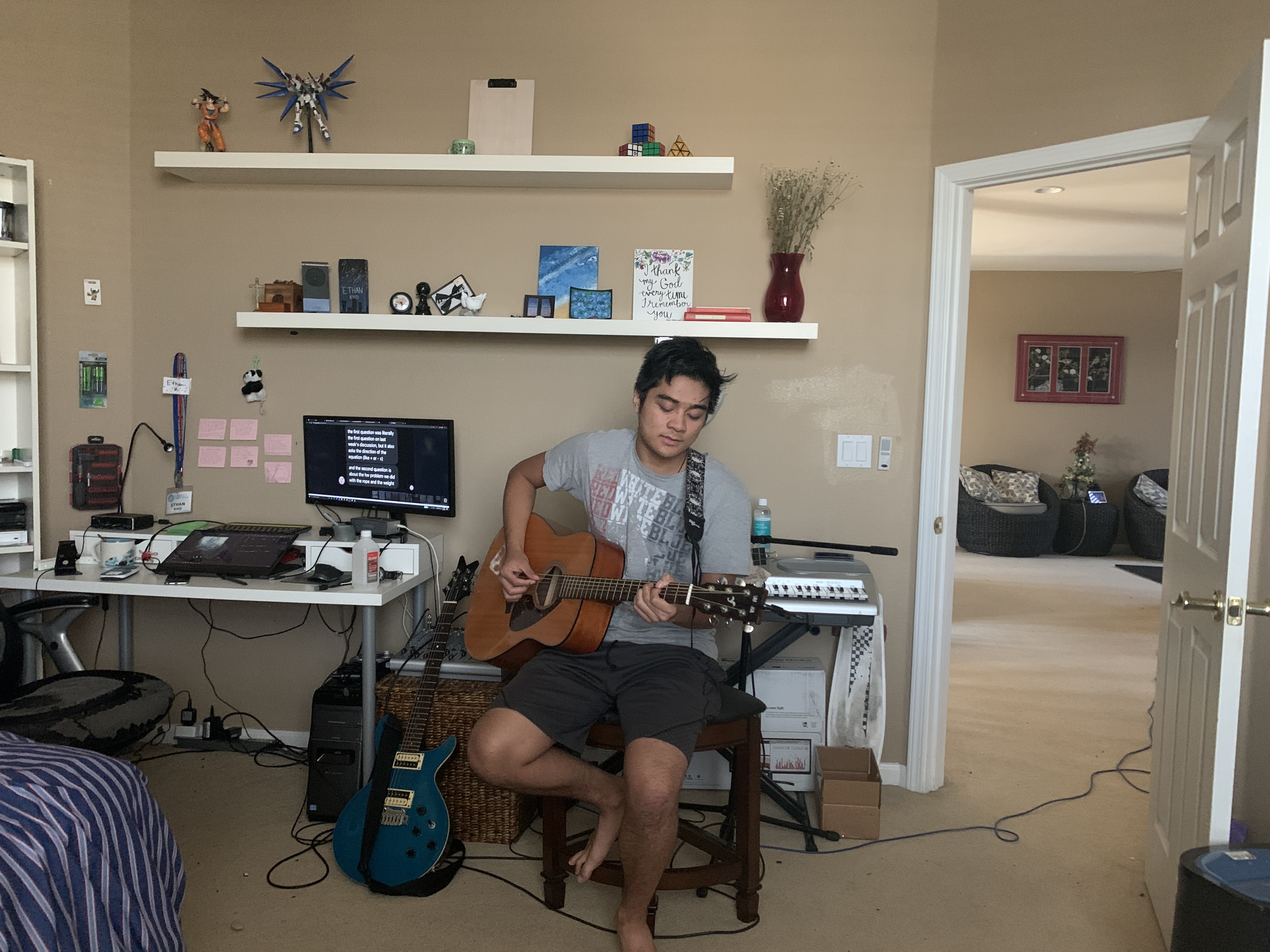 eKho playing the guitar in his room